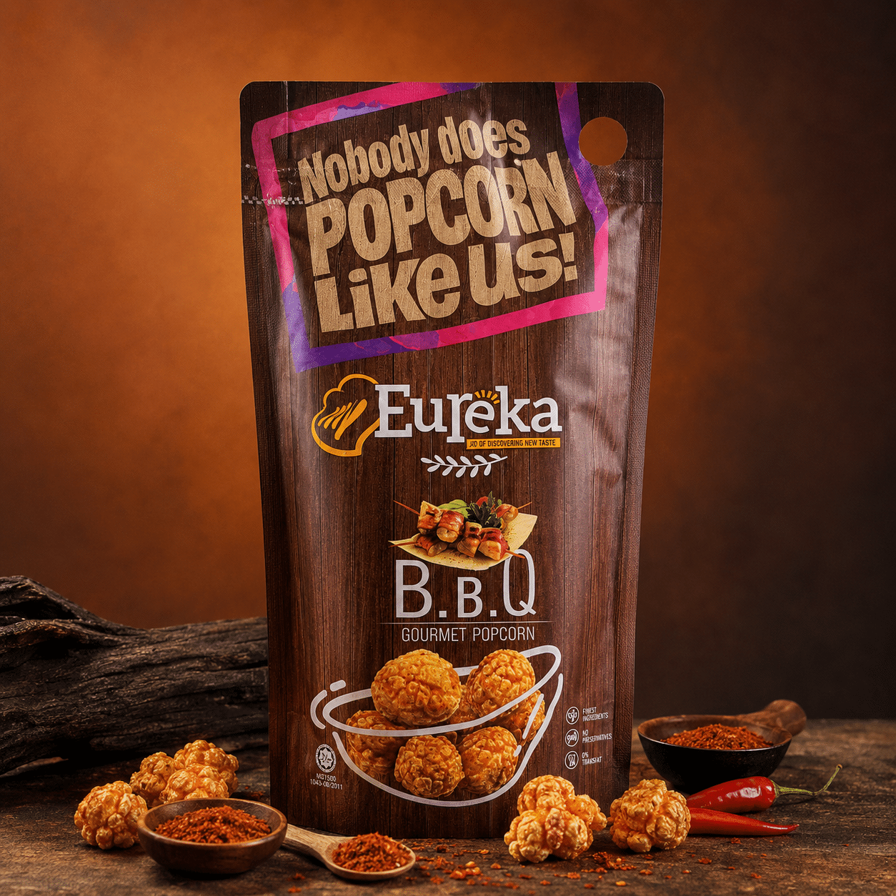 Eureka Popcorn BBQ | Snack Affair Archives Bag of Eureka BBQ Gourmet Popcorn with the slogan 'Nobody does POPCORN Like us!' on a wood-textured pouch, surrounded by spices and chili peppers.