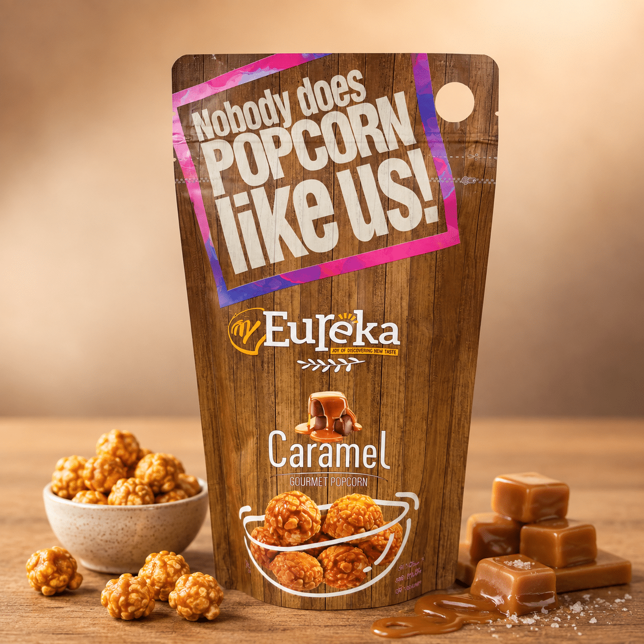 Eureka Popcorn Caramel Flavour Pouch | Snack Affair Archives Bag of Eureka Caramel Gourmet Popcorn on a wooden table, surrounded by caramel pieces and a bowl of popcorn nearby.