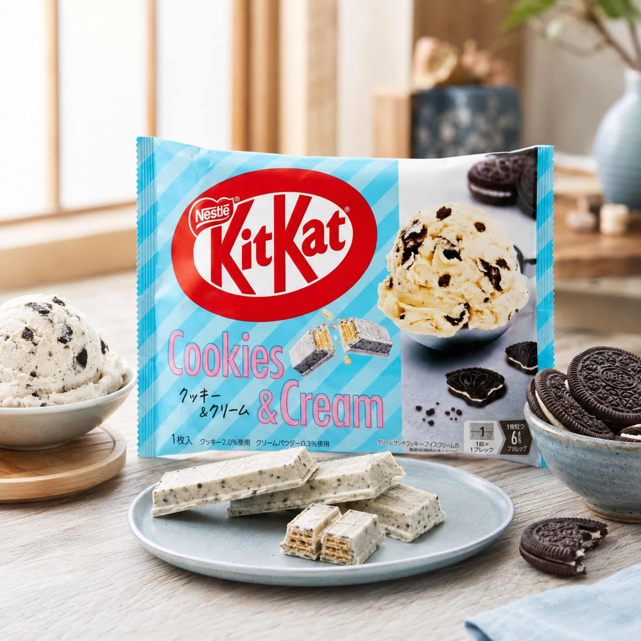 Japanese KitKat Cookies and Cream Flavour Lifestyle | Snack Affair Archives KitKat Cookies & Cream packaging visible with cookies and wafers on a wooden table