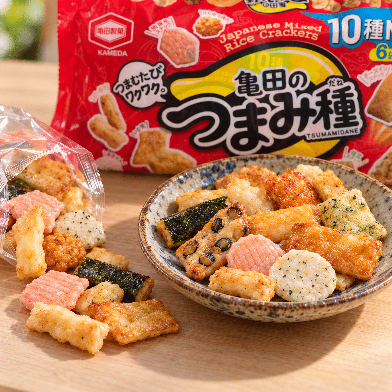 Opened Kameda mixed rice crackers3 | Snack Affair Archives Bowl of assorted rice crackers on a wooden table with a red snack bag in the background.