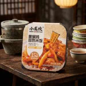 Archives Pre-packaged Chinese instant meal on a wooden table with bowls in the background; labeled SHOO LONG KAN Huang Men Ji Zi Re Mi Fan.