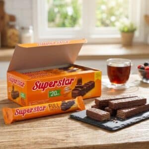Archives Open orange box of Superstar chocolate wafers on a wooden table, with several wafer bars on a slate, beside a glass cup of tea in a bright kitchen.