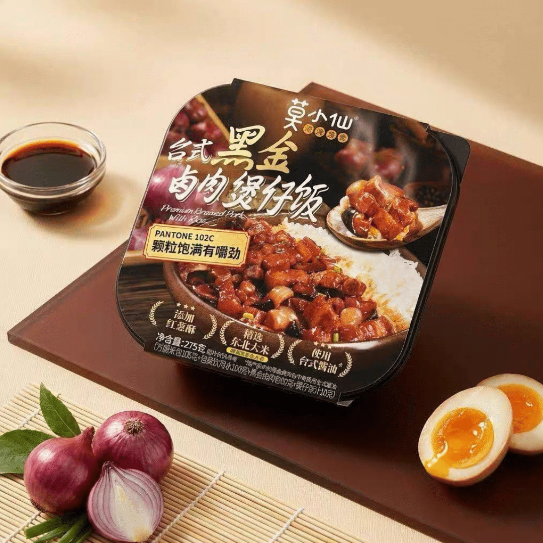 SelfHeating Taiwan Braised Pork Rice 3 | Snack Affair Archives Ready-to-eat braised pork with rice in a black packaged cup, set on a wooden tray with a small soy sauce cup nearby.