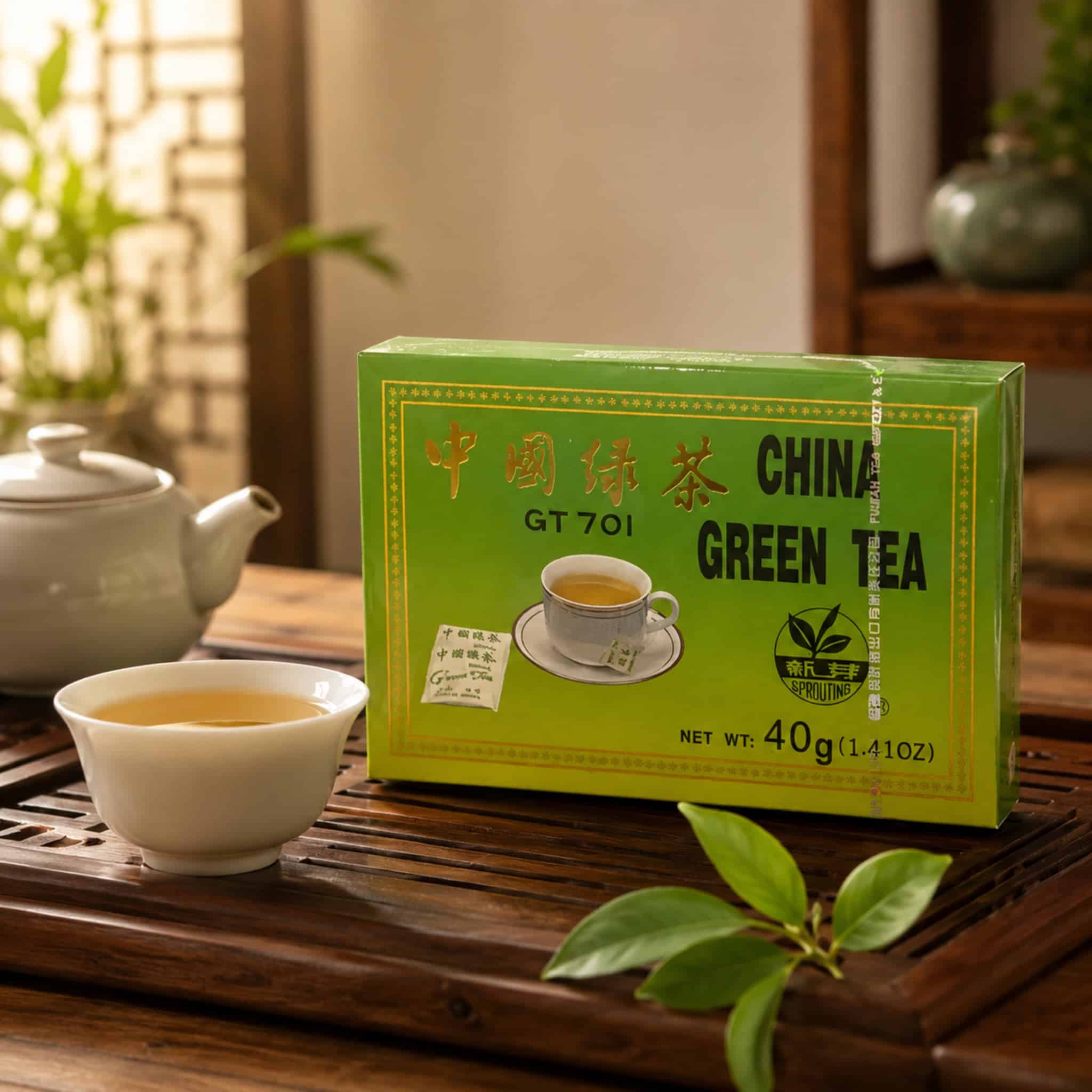 SproutingChinaGreenTeaGT70140gLifestylejpg | Snack Affair Archives Green tea box on a wooden table with a teapot and a cup in the foreground; blurred plants in the background.