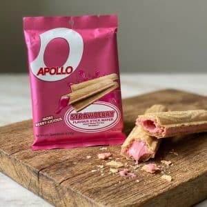 Archives Pink Apollo strawberry wafer package on a wooden board with broken pink cream-filled wafers and crumbs nearby