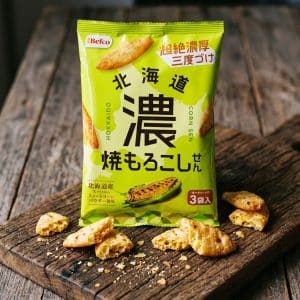 Archives Green package of Japanese corn snack on a wooden board with broken crackers around it, labeled in Japanese text.